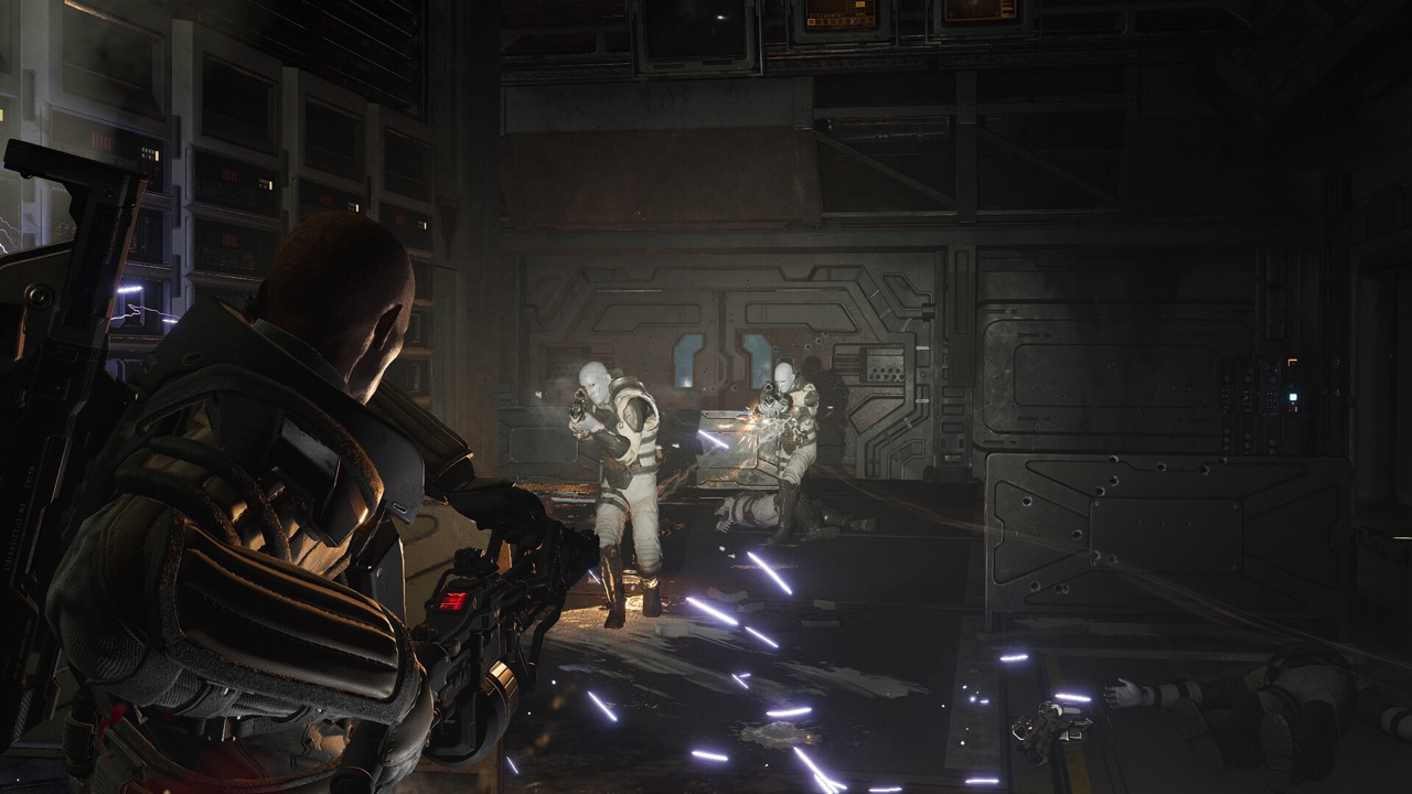 A Marine fires a primary weapon at hostile synthetics in a dark corridor